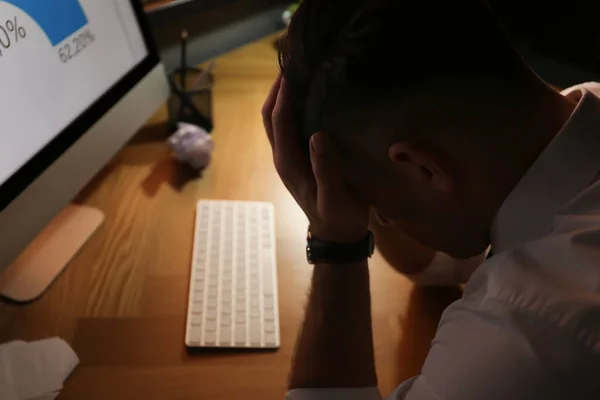 Businessman stressing out at workplace late in evening