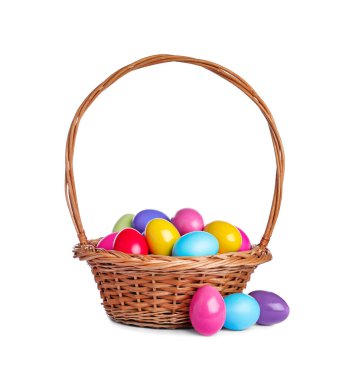 Beyaz arka planda parlak boyalı Paskalya yumurtaları olan hasır sepet.