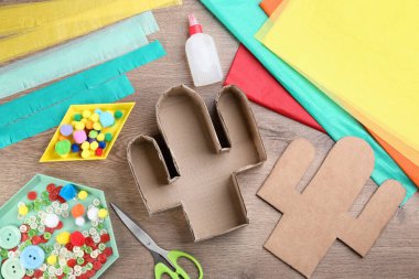Malzemeler ve aletler ahşap masada, düz yerde. Kaktüs piñata DIY