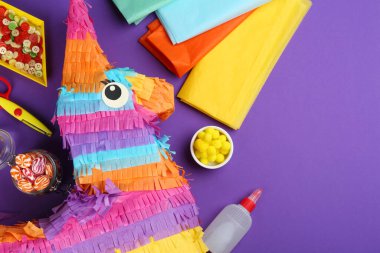 Mor zemin üzerinde karton eşek ile düz kompozisyon, metin için boşluk. Pinata diy