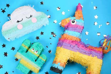 Different bright pinatas on light blue background, flat lay clipart