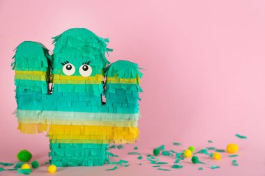 Pembe arka planda kaktüs şekilli pinata. Metin için boşluk