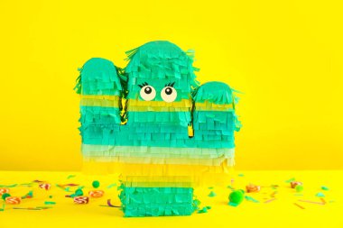 Sarı arka planda kaktüs şekilli pinata ve dekor