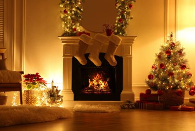 Güzel dekore edilmiş oturma odasında Noel çoraplarıyla şömine.