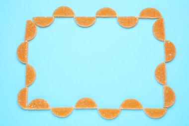 Açık mavi arkaplanda turuncu marmelatlı şekerlemelerle yapılmış, düz. Metin için boşluk