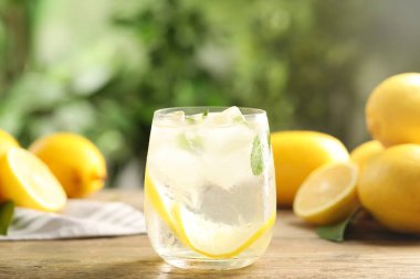 Ahşap masada camdan yapılmış taze limonata.