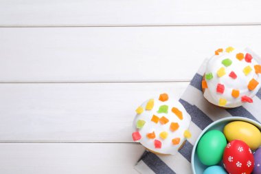 Paskalya pastaları ve beyaz ahşap masa üzerinde renkli yumurtalar, düz yatak. Metin için boşluk