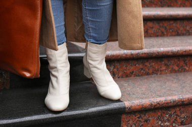 Dışarıdaki merdivenlerde çantalı şık deri ayakkabılı kadın, yakın plan.