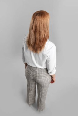 Gri arka planda genç bir kadın.