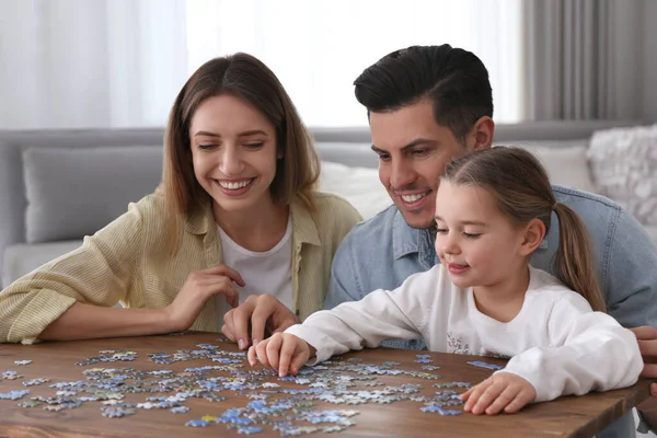 Happy family playing with puzzles at home