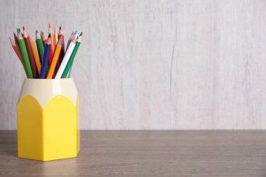 Ahşap masadaki tutucuda çok farklı kalemler, metin için boşluk