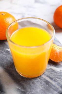 Bir bardak taze mandalina suyu ve meyve suyu.