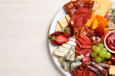 Beyaz ahşap masa üzerinde sos soslu farklı mezeler tabağı, üst manzara. Metin için boşluk