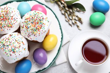 Geleneksel Paskalya pastaları ve açık gri masaya boyanmış yumurtalar.