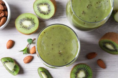 Lezzetli kivi püresi ve beyaz ahşap masa üzerindeki malzemeler.