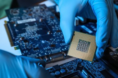 Masadaki bilgisayar ana kartını tamir eden teknisyen, yakın çekim. Elektronik aygıt