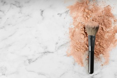 Makyaj fırçası ve dağınık yüz pudrası beyaz mermer masa, üst manzara. Metin için boşluk