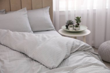 Rahat yatak, pencerenin yanında yumuşak battaniye, yakın çekim.