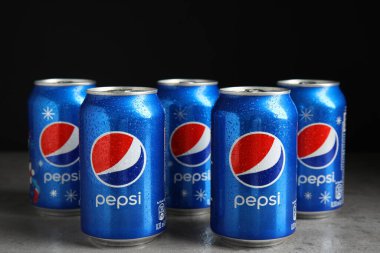 MYKOLAIV, UKRAINE - 9 Şubat 2021: Çok sayıda Pepsi kutusu siyah arkaplana karşı masada