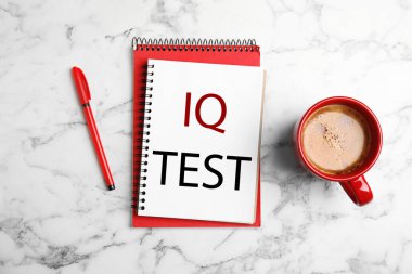 Metin IQ testi, beyaz mermer masa üzerinde kahve ve kalem içeren defter, düz konum