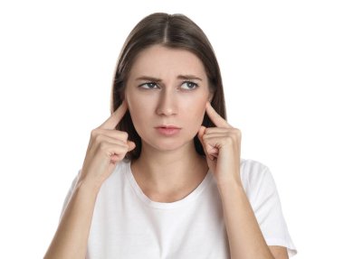 Duygusal genç kadın kulaklarını beyaz arka planda parmaklarıyla kapatıyor.