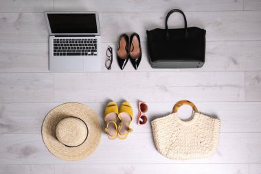 Beyaz ahşap arka planda tatil aksesuarları olan iş eşyalarının düz kompozisyonu. Yaşam ve iş dengesi kavramı