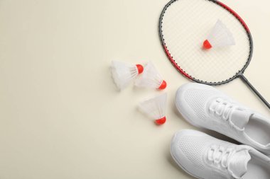 Badminton raketi, mekik horozu ve arka planda ayakkabılar, düz yatış. Metin için boşluk