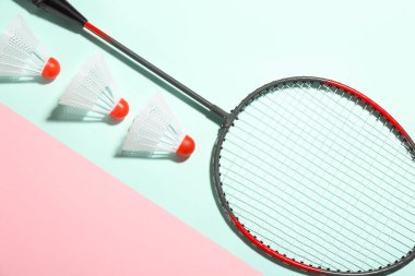 Badminton raketi ve renkli arka planda mekik horozları, düz yatıyordu