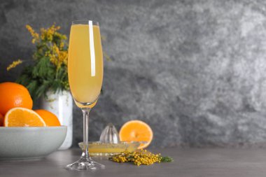 Gri masada bir bardak Mimosa kokteyli. Metin için boşluk
