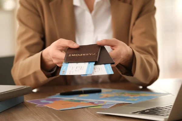 Travel agent with tickets and passports in office, closeup