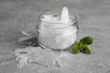 Mentollü kristaller ve gri arkaplanda taze nane yaprakları