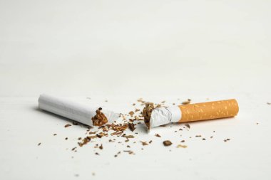 Kırık sigara beyaz masada, yakın plan. Sigarayı bırakma kavramı