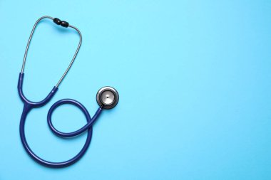 Açık mavi arka planda steteskop, üst manzara. Metin için boşluk