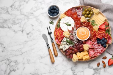 Tahta tabak, beyaz mermer masada değişik lezzetli atıştırmalıklar, düz yatış. Metin için boşluk