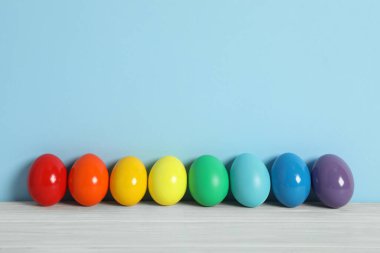 Beyaz ahşap masa üzerinde paskalya yumurtaları açık mavi arkaplan, metin için boşluk