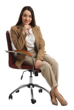 Beyaz arka planda rahat bir ofis koltuğunda oturan genç iş kadını.