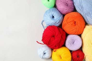 Beyaz arka planda farklı renkte yün iplikler, düz yatış. Metin için boşluk