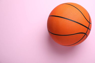 Pembe arka planda turuncu top, yazı için yeri olan üst manzara. Basketbol ekipmanları