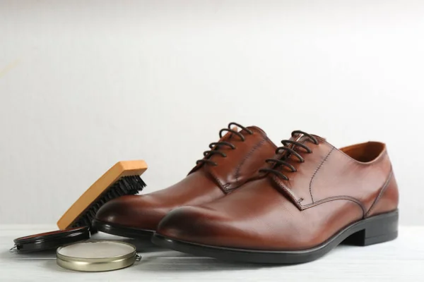 Shoe care products and footwear on white table