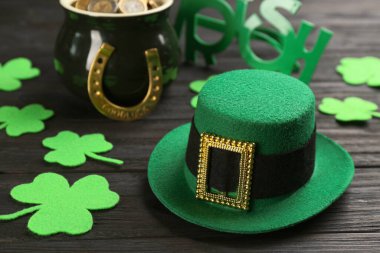 Leprikon şapkası ve Aziz Patrick günü dekoru siyah ahşap masada.