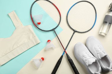 Badminton raketleri ve renk arkaplan üzerinde mekik horozları ile düz kompozisyon yatıyordu