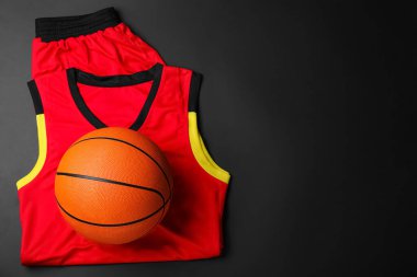 Basketbol forması ve siyah arka planda top, üst manzara. Metin için boşluk