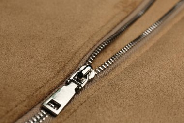 Arka planda fermuar olan bej ceket, yakın plan görünümü