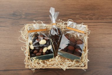 Çikolata ve kahve çekirdekli hediye kutusu ahşap masa, üst manzara.