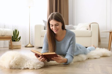 Evde kitap okuyan güzel bir genç kadın. Zemin ısıtma konsepti