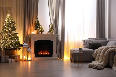 Güzel şöminesi ve Noel ağacı olan şık bir oturma odası.