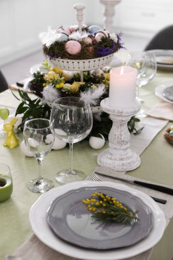 Güzel Paskalya sofrası. Kapalı mekanda çiçek dekoru var.