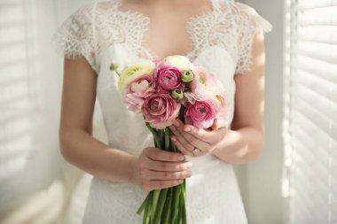 Güzel ranunculus buketi olan gelin, yakın plan.