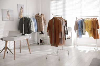 Moda giysileri ve dizüstü bilgisayarı olan modern bir butik.