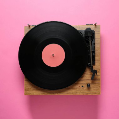Pembe arka planda vinil plaklı modern turntable, üst görünüm